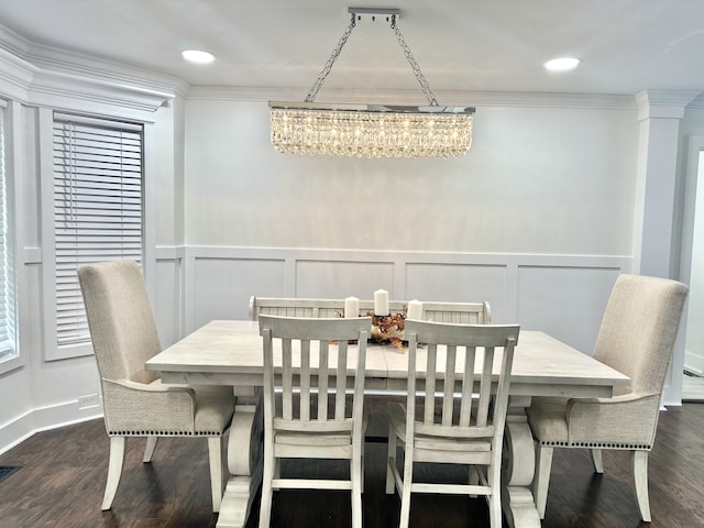 dining space with crown molding, dark hardwood / wood-style floors, a notable chandelier, and decorative columns