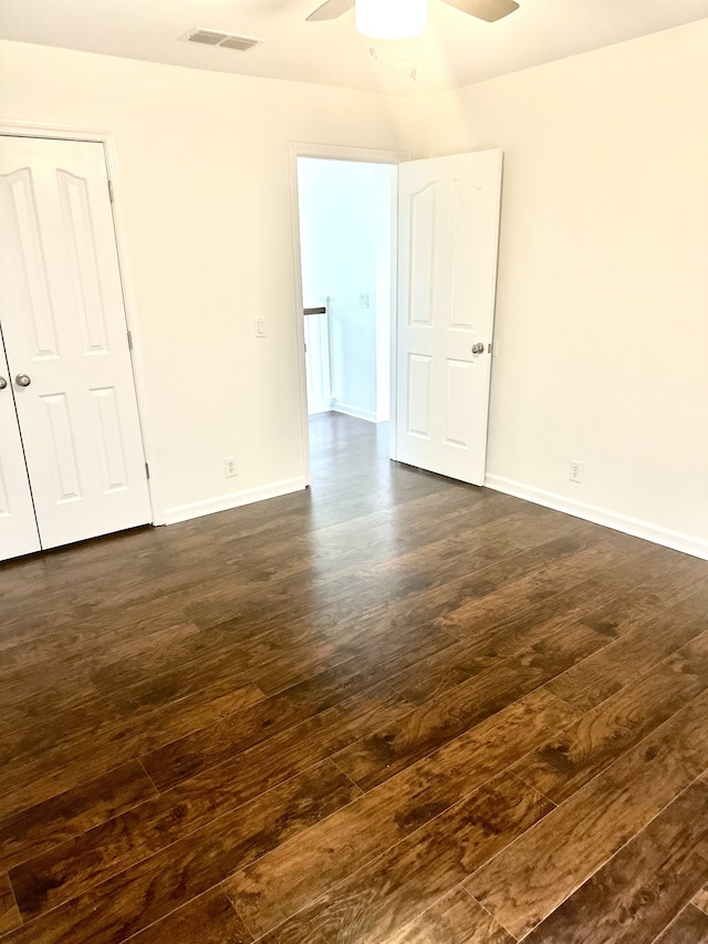 unfurnished room with dark wood-type flooring and ceiling fan