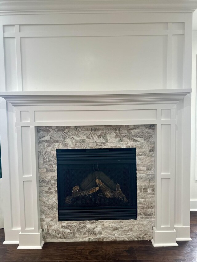 details featuring a stone fireplace and hardwood / wood-style flooring