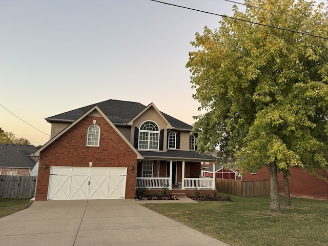 view of front of home featuring a lawn, a garage, and a porch