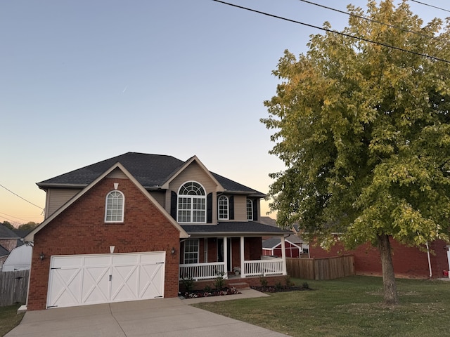 view of front of house with a lawn, a porch, and a garage