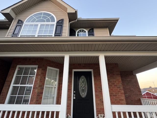 exterior entry at dusk with covered porch