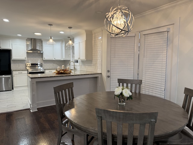 dining room with ornamental molding, a notable chandelier, and dark hardwood / wood-style floors