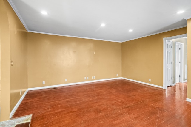 empty room featuring crown molding and hardwood / wood-style flooring