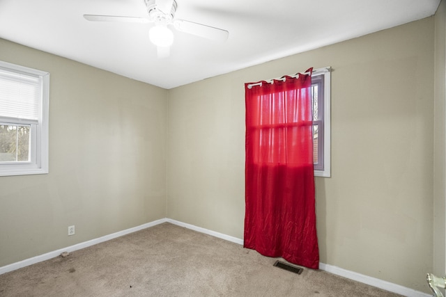 spare room with ceiling fan and light colored carpet