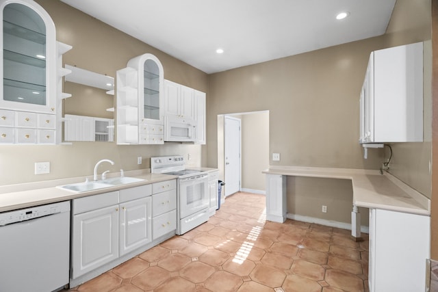 kitchen featuring sink, white cabinets, white appliances, and light tile patterned floors