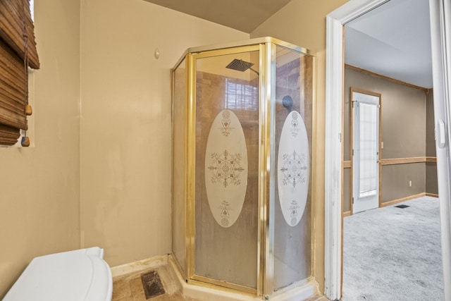 bathroom with a wealth of natural light, crown molding, toilet, and walk in shower