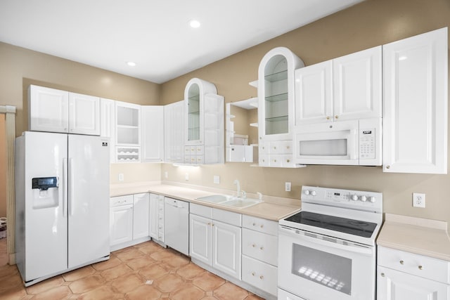 kitchen with white appliances, white cabinetry, and sink