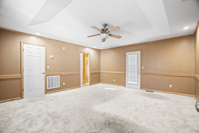 carpeted spare room featuring ceiling fan and a tray ceiling