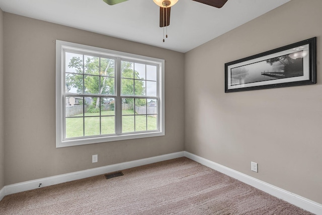 carpeted spare room featuring ceiling fan