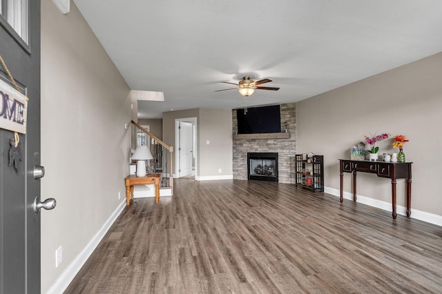 unfurnished living room featuring ceiling fan, wood-type flooring, and a fireplace