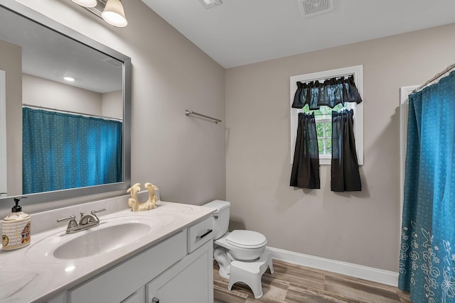 bathroom with vanity, hardwood / wood-style flooring, and toilet