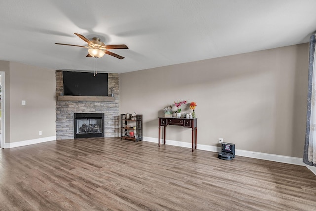 unfurnished living room featuring a fireplace, wood-type flooring, and ceiling fan