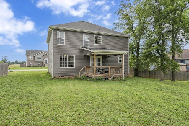 rear view of property featuring a lawn and a deck