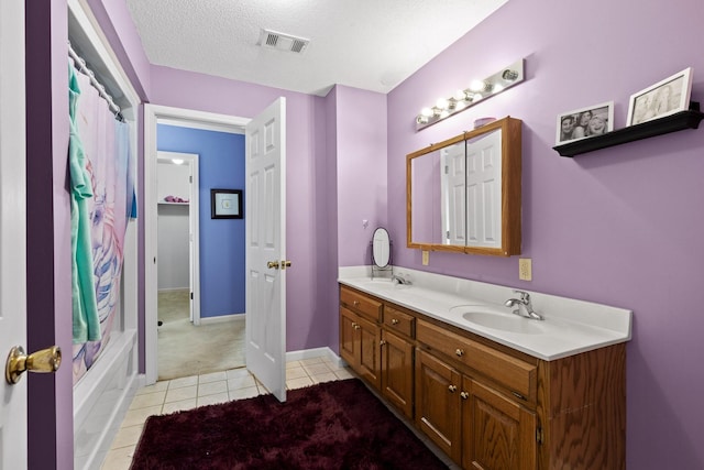 bathroom featuring vanity, shower / bath combo, tile patterned floors, and a textured ceiling