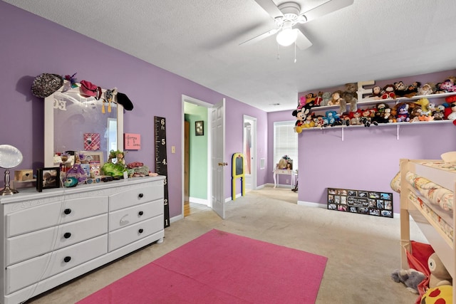 bedroom featuring ceiling fan, light colored carpet, and a textured ceiling