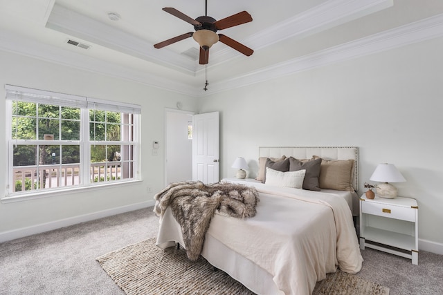 carpeted bedroom with ceiling fan, a tray ceiling, and ornamental molding