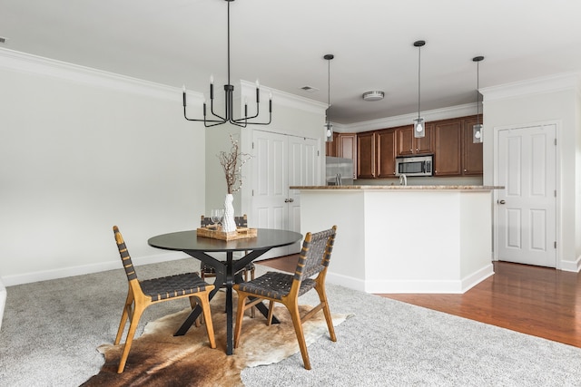 dining room featuring hardwood / wood-style flooring, crown molding, and an inviting chandelier