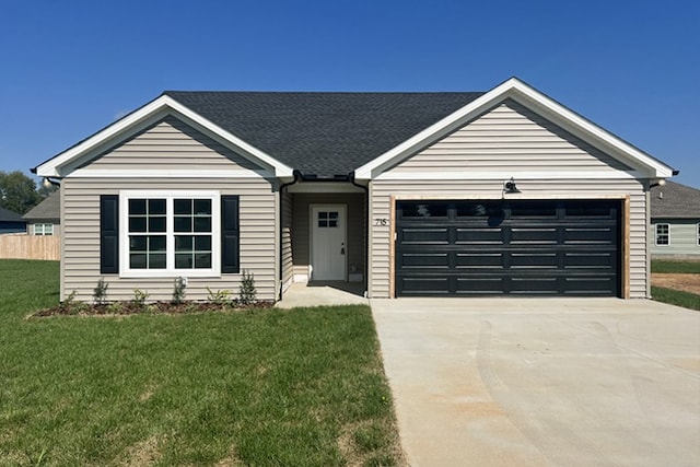 single story home featuring a garage, driveway, and a front lawn