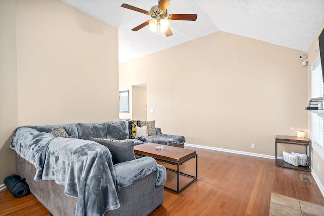 living room with vaulted ceiling, a textured ceiling, ceiling fan, and hardwood / wood-style floors