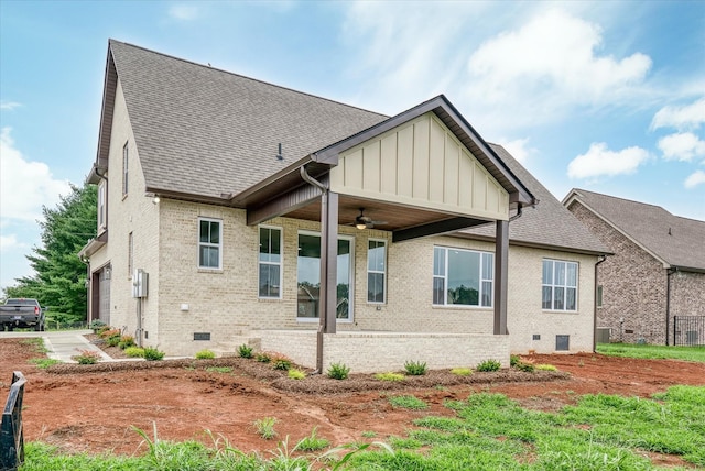 rear view of property with ceiling fan and a garage