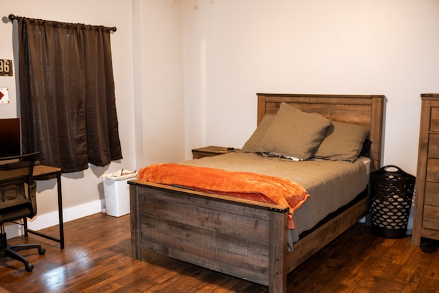 bedroom with dark hardwood / wood-style flooring