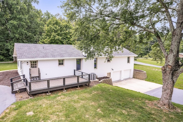 rear view of property featuring central AC, a yard, a deck, and a garage