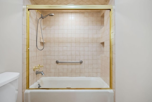 bathroom with tiled shower / bath and toilet