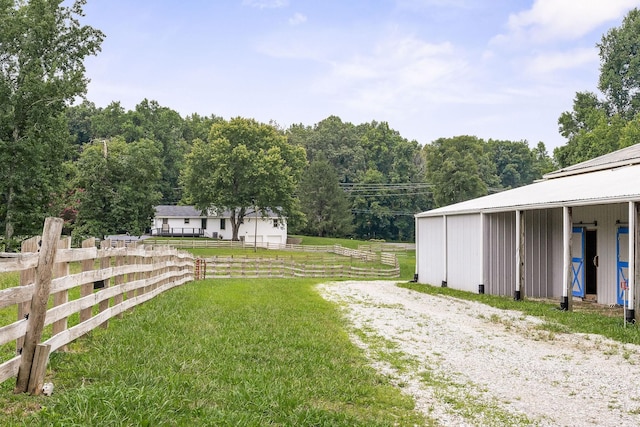 view of yard with an outdoor structure and a rural view