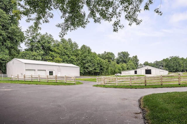 view of patio featuring a garage, an outdoor structure, and a rural view