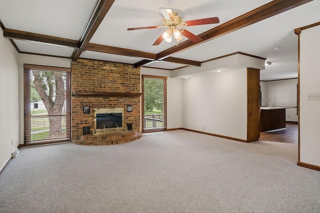 unfurnished living room with coffered ceiling, carpet flooring, beam ceiling, and a brick fireplace