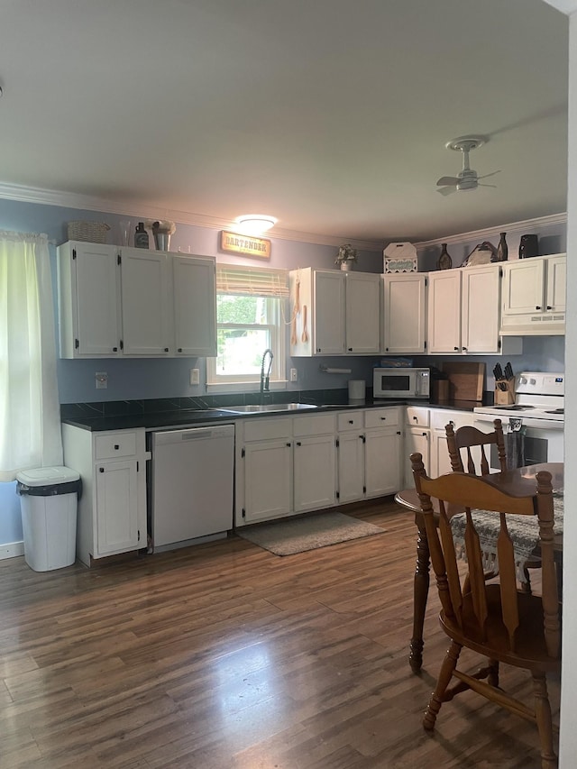 kitchen featuring sink, white appliances, dark hardwood / wood-style floors, ornamental molding, and white cabinets