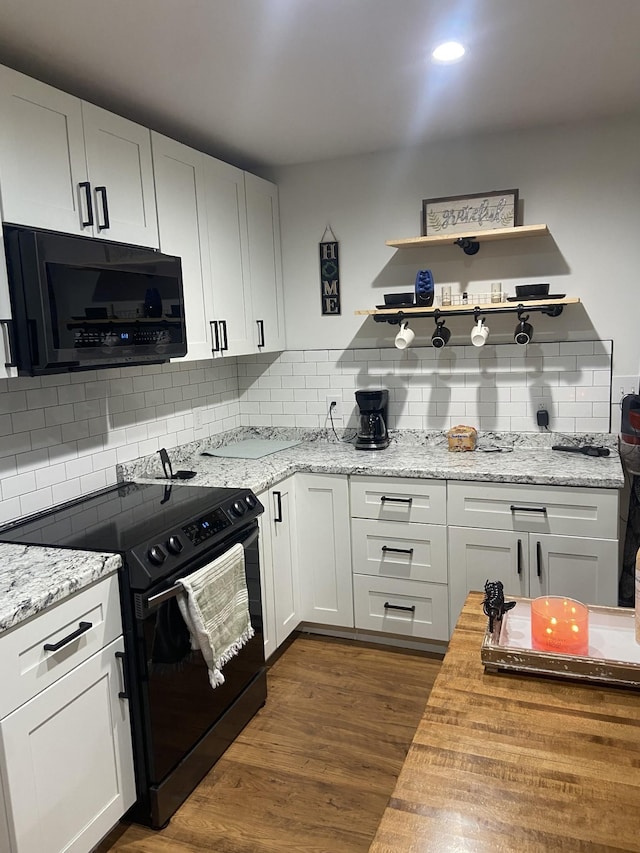 kitchen featuring white cabinetry, black electric range oven, dark wood-type flooring, and backsplash