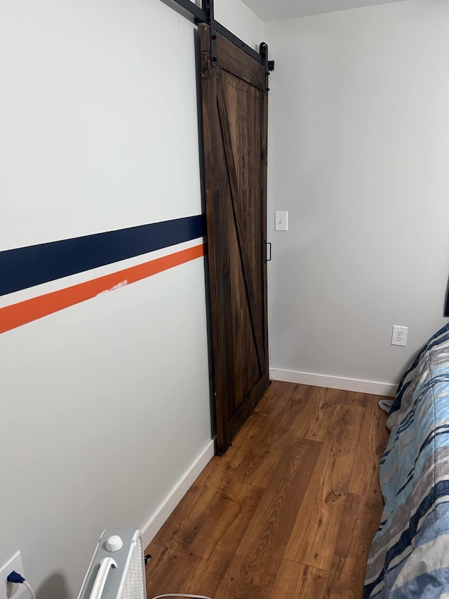 interior space with dark hardwood / wood-style flooring and a barn door