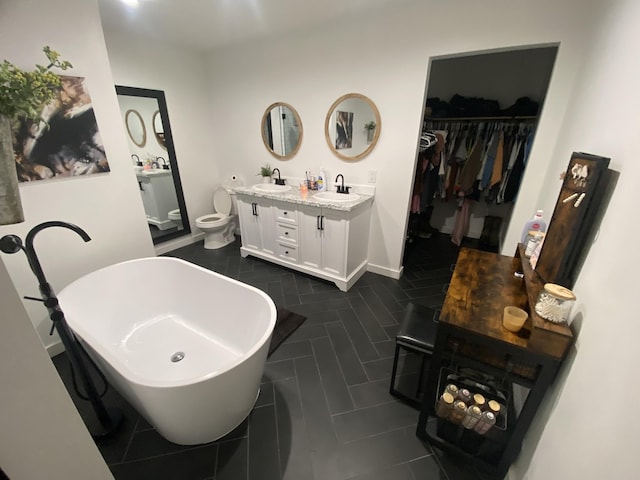 bathroom featuring vanity, a tub, and toilet