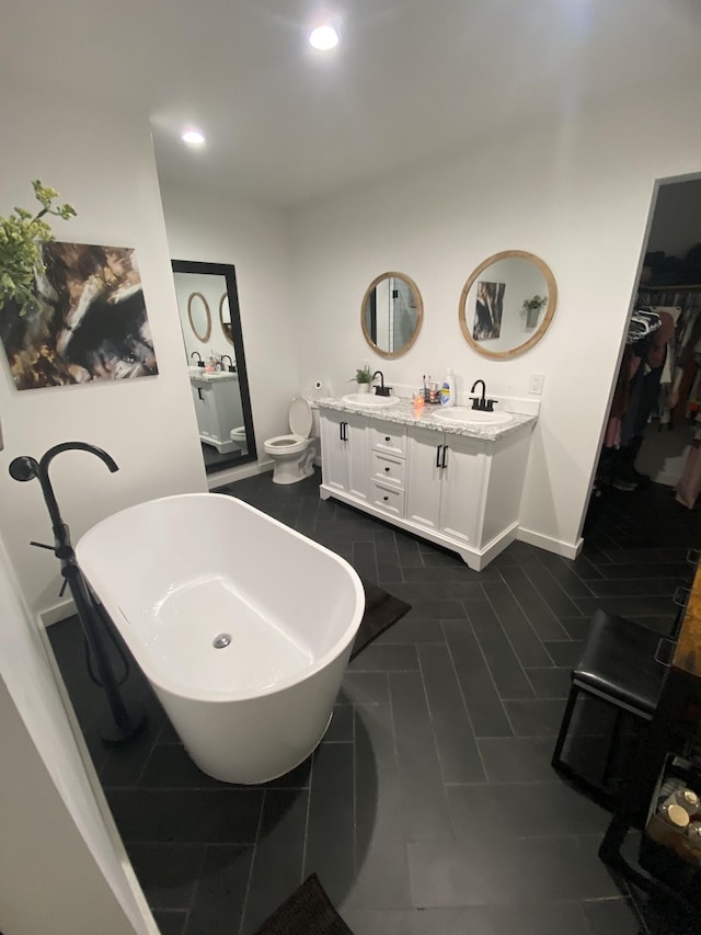 bathroom with vanity, a bathtub, and toilet