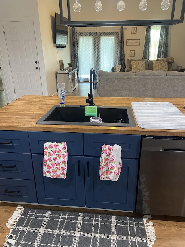 kitchen with blue cabinetry, dishwasher, and sink