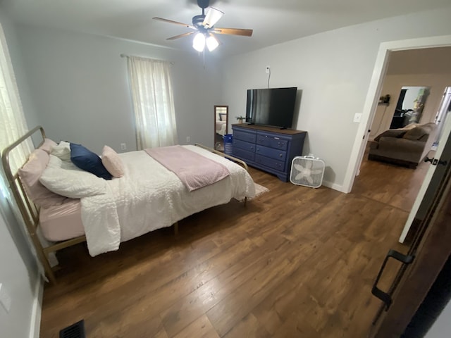 bedroom with dark hardwood / wood-style flooring and ceiling fan