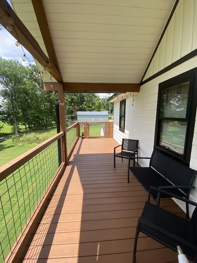 wooden deck with a yard, grilling area, and a storage shed