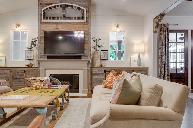 living room featuring lofted ceiling, a healthy amount of sunlight, hardwood / wood-style floors, and a fireplace