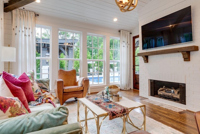 sunroom featuring lofted ceiling, a brick fireplace, and wood ceiling