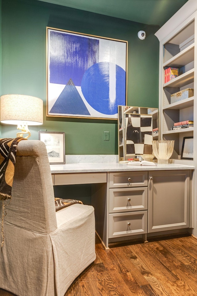 home office featuring dark hardwood / wood-style floors and built in desk