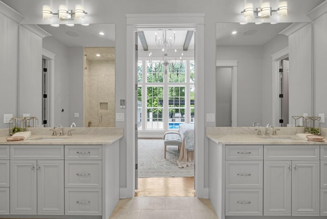 bathroom featuring beamed ceiling, tile patterned floors, a chandelier, and vanity