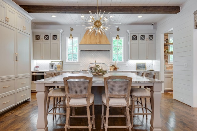 kitchen with beamed ceiling, a center island, pendant lighting, and dark hardwood / wood-style floors