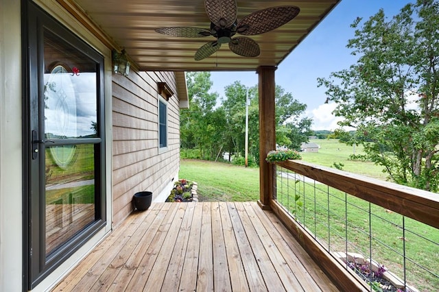 wooden terrace with ceiling fan and a lawn