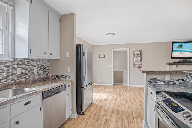 kitchen with white cabinetry, decorative backsplash, light hardwood / wood-style flooring, and appliances with stainless steel finishes