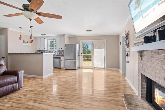 living room with a brick fireplace, crown molding, and light hardwood / wood-style floors