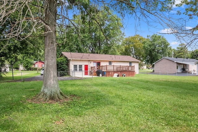 back of property featuring a wooden deck and a yard