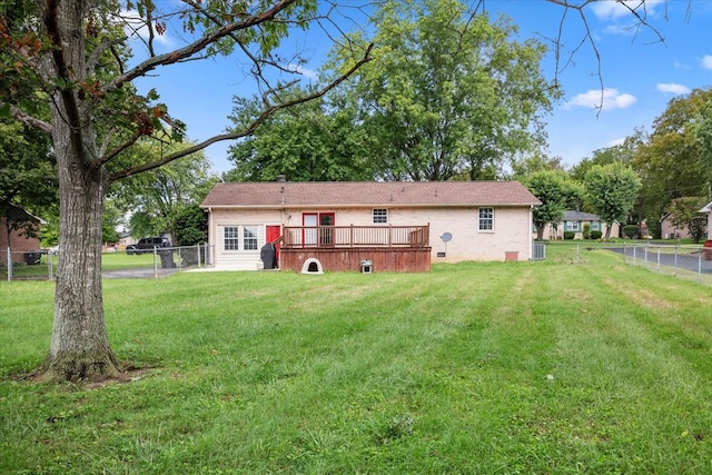 rear view of house featuring a lawn and a deck