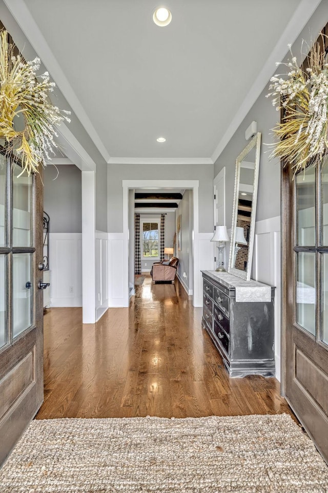 foyer with dark wood-type flooring and ornamental molding